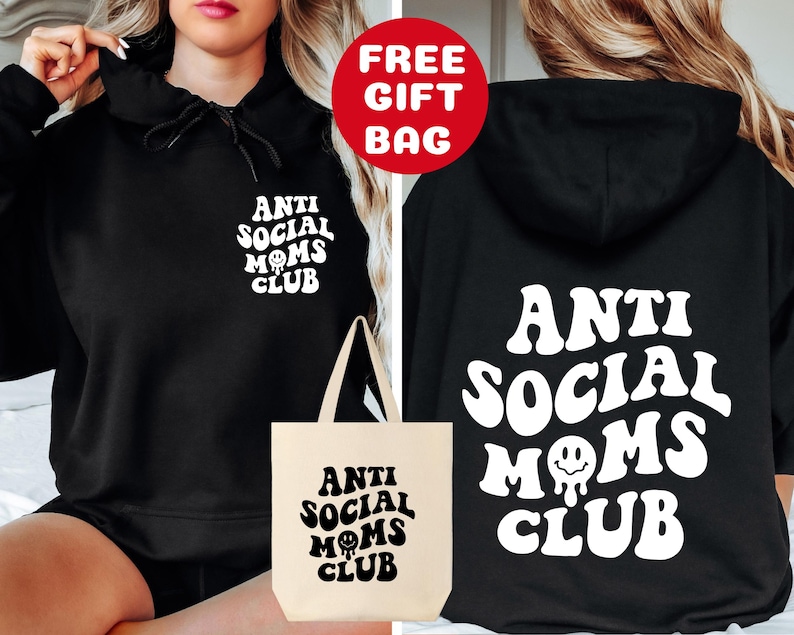 May include: Black hooded sweatshirt with the text "Anti Social Moms Club" in white, featuring a dripping smiley face. A matching tote bag with the same design is also pictured.