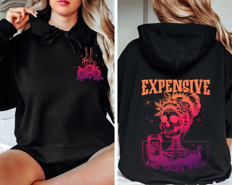 May include: Black hoodie with a pink and orange gradient design. The front features a skeleton hand making a peace sign with roses. The back features a skeleton with a bun, drinking from a cup with the text "Expensive and Talks Back".