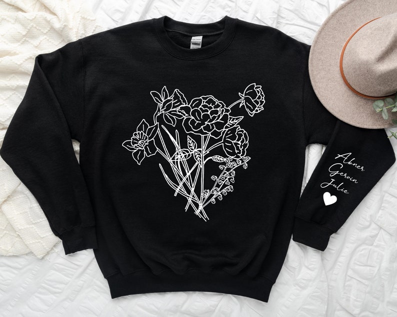 May include: Black sweatshirt with a white outline of a bouquet of flowers on the front. The left sleeve has the names "Abner, Gerwin, Julie" written in white with a white heart symbol.