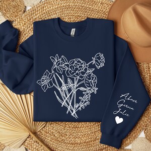 May include: Navy blue sweatshirt with a white floral design and the names "Abner, Gerwin, Julie" and a heart on the sleeve.