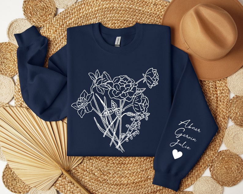 May include: Navy blue sweatshirt with a white floral design and the names "Abner, Gerwin, Julie" and a heart on the sleeve.