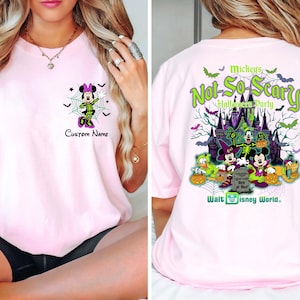 K&ouml;nnte beinhalten: Hellrosa T-Shirt mit Halloween-Motiv. Auf der Vorderseite befindet sich ein Minnie Mouse-Design mit dem Text "Custom Name". Auf der R&uuml;ckseite ist "Mickey's Not-So-Scary Halloween Party" mit Disney-Figuren und einem Spukschloss abgebildet.