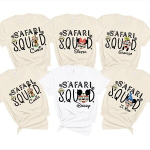 K&ouml;nnte beinhalten: Eine Sammlung cremefarbener und wei&szlig;er T-Shirts mit dem schwarzen Schriftzug "SAFARI SQUAD". Jedes Shirt hat eine andere Charaktergrafik und Familienrolle: Cousin, Schwester, Opa, Daddy und Lil Bro. Ein lustiges Familienthema.
