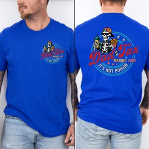 May include: Royal blue t-shirt with a circular graphic featuring a skeleton wearing a baseball cap, holding a drink and fries. The text reads "Dad Tax, Making Sure It's Not Poison."