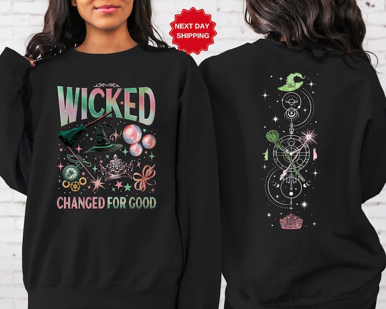 Puede incluir: Sudadera negra con las palabras "WICKED CHANGED FOR GOOD" en una fuente colorida y caprichosa. El dise&ntilde;o frontal incluye un sombrero de bruja, una escoba y burbujas. La parte trasera presenta un sombrero de bruja, una escoba y un dise&ntilde;o geom&eacute;trico.
