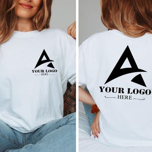 May include: White t-shirt with a black triangle logo that says "YOUR LOGO HERE" on the front and back.