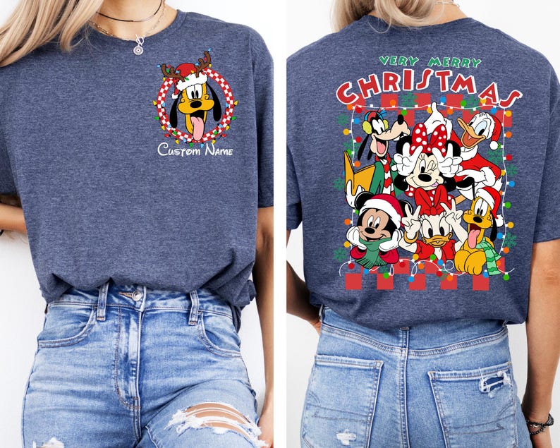 Op de afbeelding: Een marineblauw T-shirt met een kerstthema met Mickey Mouse, Minnie Mouse, Donald Duck, Goofy en Pluto. De voorkant van het shirt heeft een krans met Pluto die een kerstmanmuts draagt. De achterkant van het shirt zegt "Prettige Kerst" met de personages in een feestelijke sc&egrave;ne.
