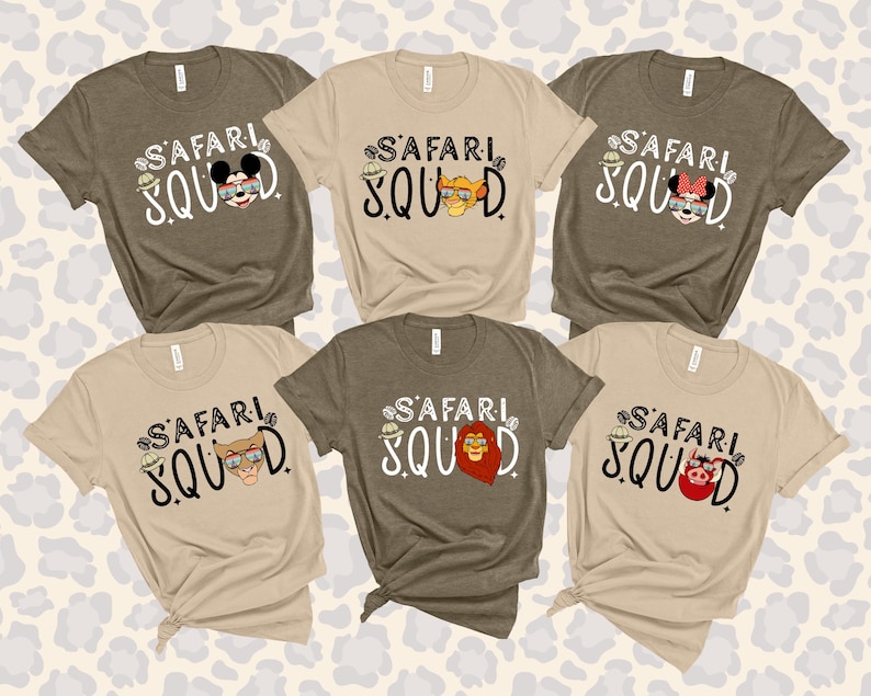 K&ouml;nnte beinhalten: Sechs kurz&auml;rmelige T-Shirts in verschiedenen neutralen Farben, jeweils mit den Worten "SAFARI SQUAD" in einer verspielten Schriftart. Die Shirts haben Cartoon-Charakter-Designs, darunter eine Maus, ein L&ouml;we und ein Schwein mit Safarih&uuml;ten.