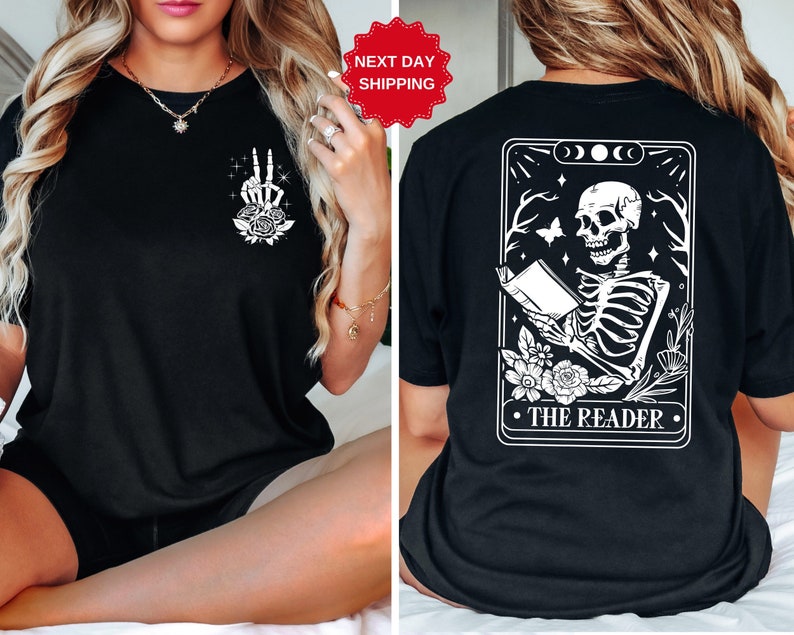以下が含まれることがあります： 黒のTシャツ。背面には白い骨格が本を読んでいるイラストと「THE READER」の文字。前面には白い手とバラのイラストが描かれている。