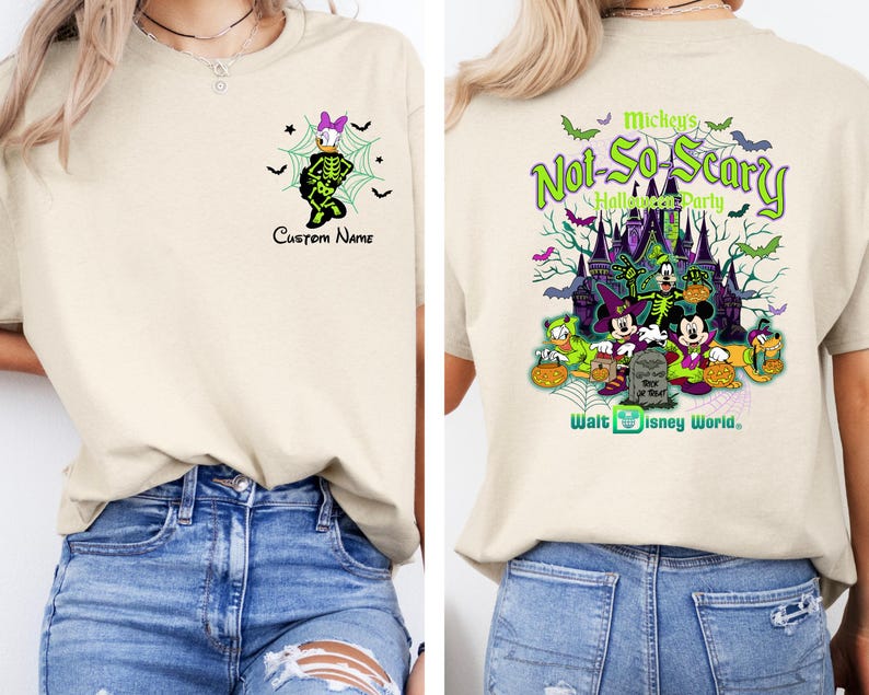 K&ouml;nnte beinhalten: Cremefarbenes T-Shirt mit Halloween-Motiv. Auf der Vorderseite ist Daisy Duck im Skelettkost&uuml;m mit dem Text "Custom Name" abgebildet. Auf der R&uuml;ckseite ist eine gruselige Schlossszene mit Disney-Figuren und dem Text "Mickey's Not-So-Scary Halloween Party" zu sehen.