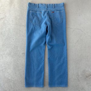 May include: A pair of light blue denim jeans with a red Levi's label on the back pocket.