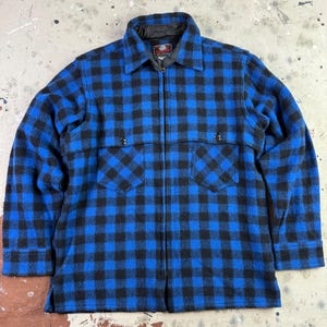Peut inclure: Veste à carreaux bleus et noirs avec fermeture éclair intégrale. La veste a un col, deux poches poitrine et une doublure noire. Fabriquée dans une matière épaisse et chaude, idéale pour le froid.