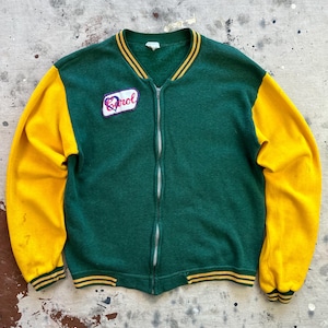 May include: A green and yellow vintage varsity jacket with a full zipper closure. The jacket features yellow sleeves and a patch that says "Carol". The jacket has a ribbed collar, cuffs, and hem with yellow stripes.