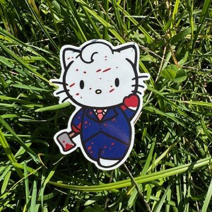 Puede incluir: Un gato de dibujos animados blanco con salpicaduras de pintura roja en la cara, que lleva un traje azul y sostiene un hacha. El gato tiene un coraz&oacute;n rojo en el pecho y una corbata roja.