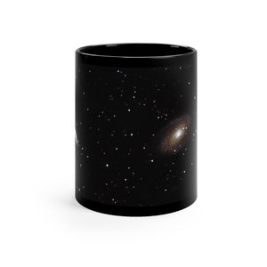 May include: Black ceramic mug with a galaxy print featuring a swirling nebula and stars.