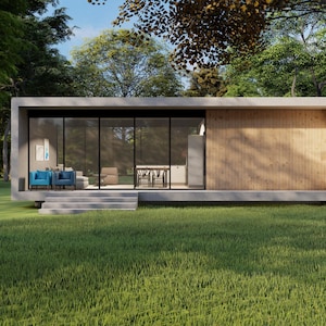 May include: Modern rectangular home with large glass windows and a wooden panel section. The home features a concrete base and a flat roof. Two blue chairs are visible inside, and the home is surrounded by green grass and trees.
