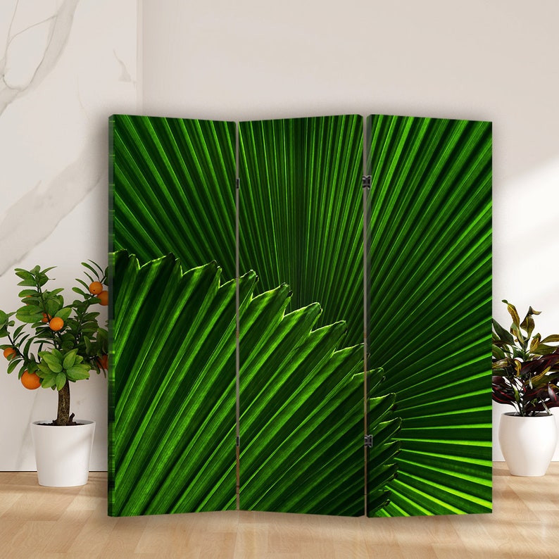 Puede incluir: Un divisor de habitaci&oacute;n de tres paneles con un dise&ntilde;o de hoja de palmera verde. Los paneles son de madera y tienen un acabado natural. El divisor es una excelente manera de agregar privacidad y estilo a cualquier habitaci&oacute;n.