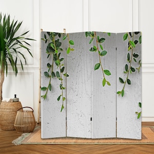 May include: A white room divider screen with a wood frame and a printed design of green vines on a white background.