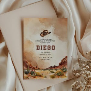 May include: A watercolor-style invitation with a desert landscape scene. The invitation features text in Spanish, including the name "Diego" and event details. A cowboy hat graphic is at the top. The invitation is on a cream-colored background.