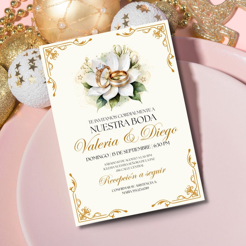 Puede incluir: Invitaci&oacute;n de boda marfil con detalles dorados y dise&ntilde;o floral. La invitaci&oacute;n presenta el texto "Nuestra Boda" y los nombres "Valeria & Diego". Se muestran anillos de boda dorados. La invitaci&oacute;n est&aacute; rodeada de adornos dorados.
