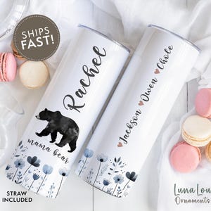 May include: Two white stainless steel tumblers with personalised names and a floral design. One tumbler features a watercolour illustration of a black bear with the text "mama bear".
