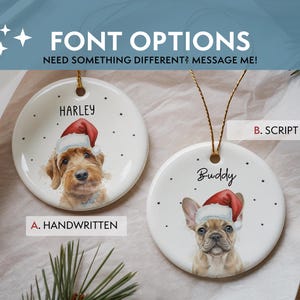 May include: Two round white ceramic ornaments featuring illustrations of dogs wearing red Santa hats. One ornament displays the name Harley in a block font, and the other shows the name Buddy in a script font. Both include gold hanging strings.