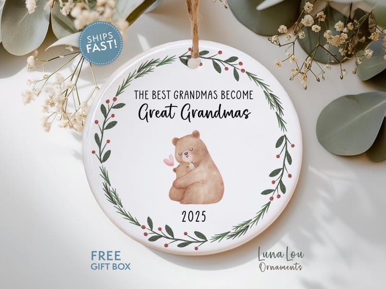 May include: A white ceramic ornament with a brown string for hanging. The ornament features the text "THE BEST GRANDMAS BECOME Great Grandmas" and a watercolor illustration of two bears. The year "2025" is printed below the bears.