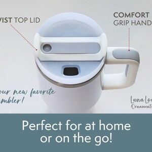 May include: White tumbler with a gray twist top lid and a comfort grip handle. The text on the image says "your new favorite tumbler!" and "Perfect for at home or on the go!"