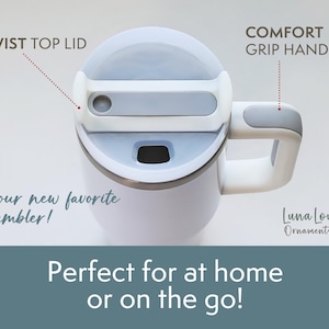 May include: White tumbler with a gray twist top lid and a comfort grip handle. The tumbler has the text "your new favorite tumbler!" and "Perfect for at home or on the go!"