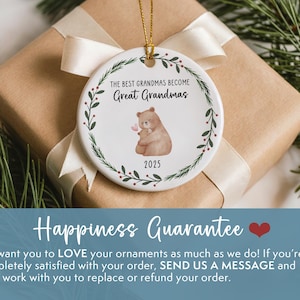 May include: A white ceramic ornament with the text "THE BEST GRANDMAS BECOME Great Grandmas" and a bear illustration. The ornament is decorated with a green leaf border and the year 2025. It is presented on a wrapped gift.
