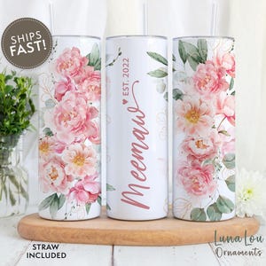 May include: Three white tumblers with pink floral designs and gold accents. The centre tumbler has the text "Meenau ♥ Est. 2022" in pink script.