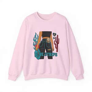 May include: Pink sweatshirt with a graphic of a woman wearing blue jeans with a dollar bill in the back pocket, flames, a cactus, and the text "BLUE STRIPS".