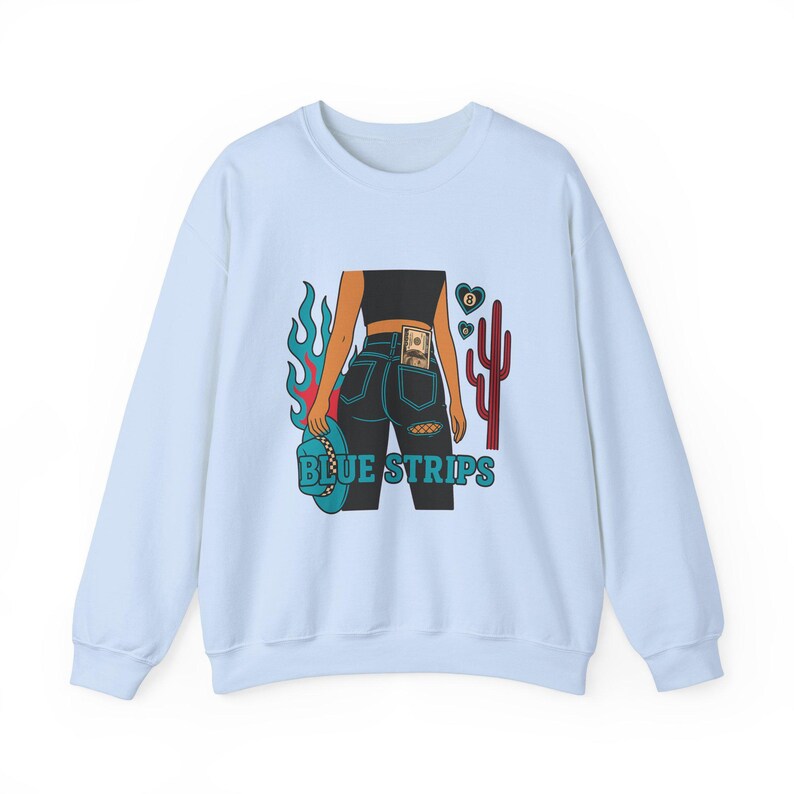 May include: Light blue sweatshirt with a graphic print of a woman in blue jeans with a dollar bill in the back pocket, a cowboy hat, flames, and a cactus. The text "BLUE STRIPS" is printed below the graphic.