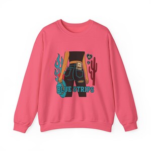 May include: Pink sweatshirt with a graphic of a woman in blue jeans with a dollar bill in her back pocket, flames, a cactus, and the text "BLUE STRIPS".