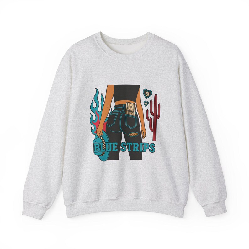 May include: A grey sweatshirt with a graphic print of a woman in blue jeans with a bill tucked in the back pocket. The graphic also includes a cactus, flames, and the text "BLUE STRIPS".