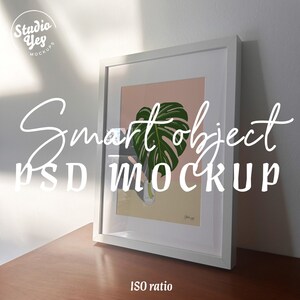 Könnte beinhalten: Weißer Rahmen mit rosa Hintergrund und einer Illustration eines grünen Monstera-Blattes. Der Text "Smart object PSD MOCKUP" ist in Weiß auf schwarzem Hintergrund geschrieben.