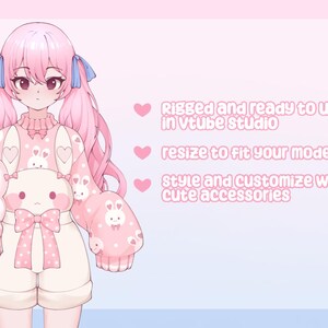 May include: Digital illustration of a pink-haired anime-style character holding two plush toys. The character wears a pink outfit with bunny and heart patterns. Text on the right says "Rigged and ready to use in vtube studio".