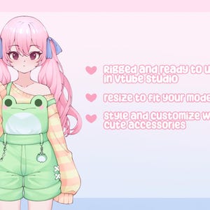 May include: An anime-style character with pink hair and a frog-themed outfit. The character is wearing a light green overall with a frog face design and a yellow and white striped sweater. Text on the right says "Rigged and ready to use in vtube studio".
