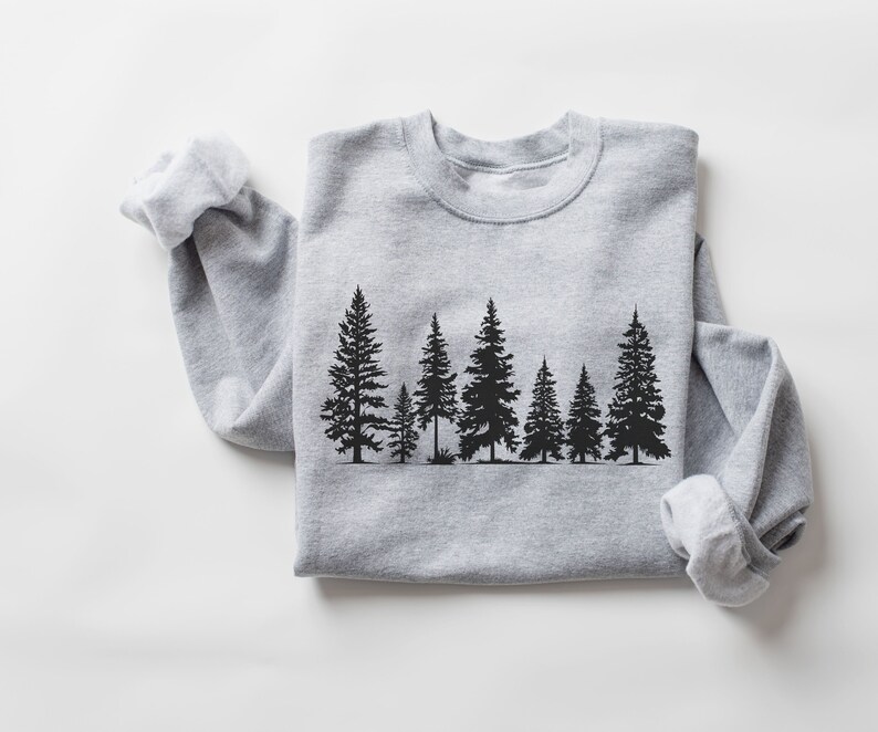 May include: A gray sweatshirt with a black silhouette of a row of pine trees printed on the front.