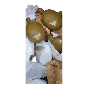 May include: Three olive green military canteens wrapped in white tissue paper and brown paper.