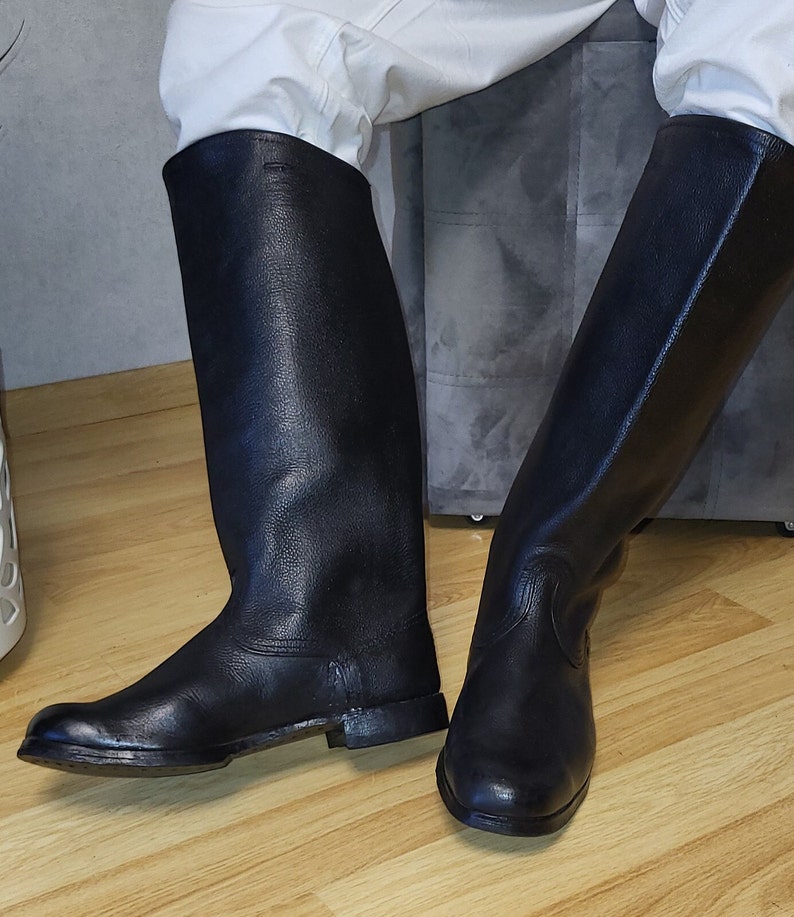 May include: A pair of black leather riding boots with a pointed toe and a low heel.