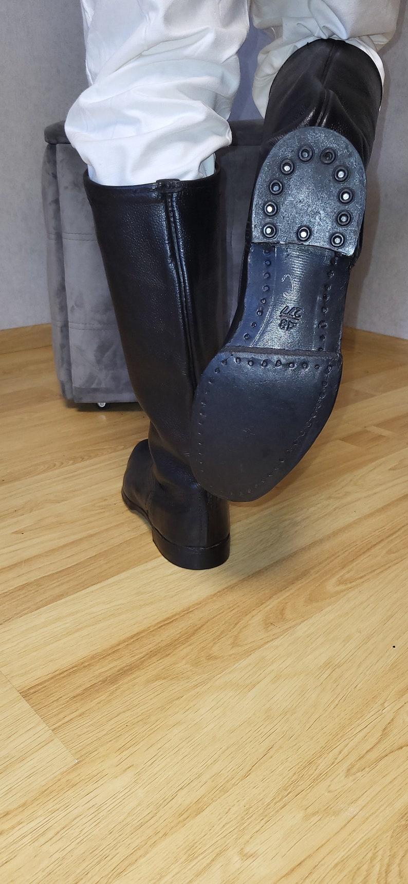 May include: Black leather riding boots with a rubber sole and a textured pattern. The sole has a size 42 printed on it.
