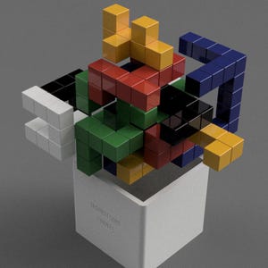 May include: A colourful 3D puzzle made of small interlocking cubes. The puzzle is assembled into a complex shape with a variety of colours, including red, green, blue, yellow, black, and white. The puzzle is sitting on top of a white box with the text "The Impossible Puzzle" printed on the side.