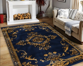 May include: A rectangular area rug featuring a deep navy blue background with a prominent gold-colored ornate floral and scrollwork pattern. The design includes a central medallion motif surrounded by intricate border detailing in a matching gold hue.
