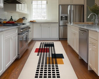 Puede incluir: Una alfombra de pasillo rectangular con fondo color crema y un patrón geométrico de líneas de cuadrícula negras, un cuadrado rojo sólido, un cuadrado negro sólido y un cuadrado naranja sólido dispuestos linealmente sobre un suelo de cocina de madera.