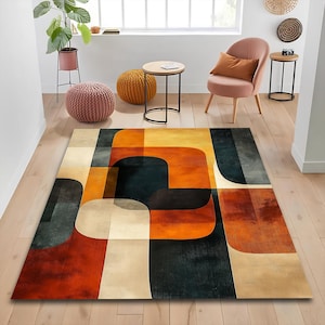 May include: A rectangular area rug featuring a geometric pattern of overlapping rounded shapes in shades of burnt orange, deep charcoal grey, and cream. The design consists of large, smooth-edged blocks of colour that create a layered effect.