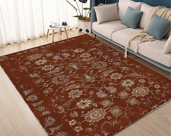 May include: A rectangular area rug featuring a deep rust-orange background with an intricate, repeating floral and vine pattern in shades of cream, beige, and muted brown. The design includes stylized blossoms and scrolling foliage across the surface.