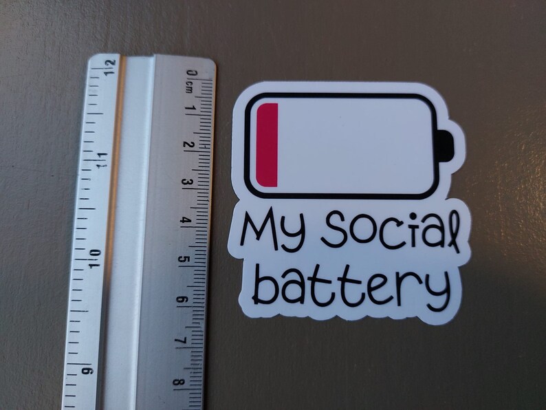 May include: A white sticker with a black outline of a battery icon. The battery is almost empty, with only a small red bar at the top. The text "My Social battery" is written below the battery icon.