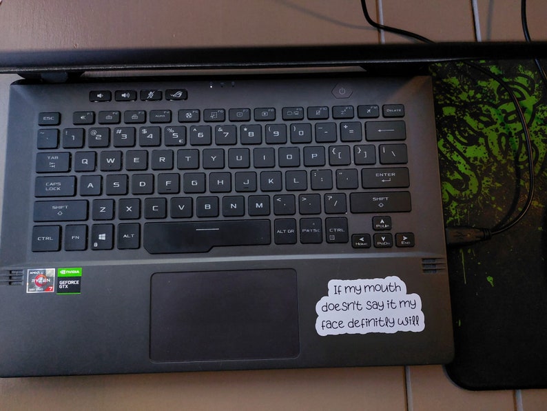 May include: A black laptop computer with a sticker that reads "If my mouth doesn't say it my face definitely will".