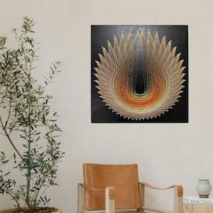 Könnte beinhalten: Ein String-Art-Bild mit einem geometrischen Design in Gelb-, Orange- und Brauntönen. Die Kunst ist auf einem schwarzen Hintergrund montiert und wird an einer weißen Wand in einem Wohnzimmer ausgestellt.